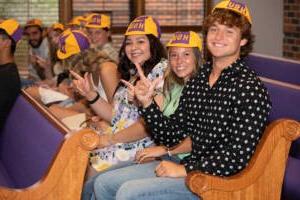 Students wear their beanies in Logsdon Chapel.